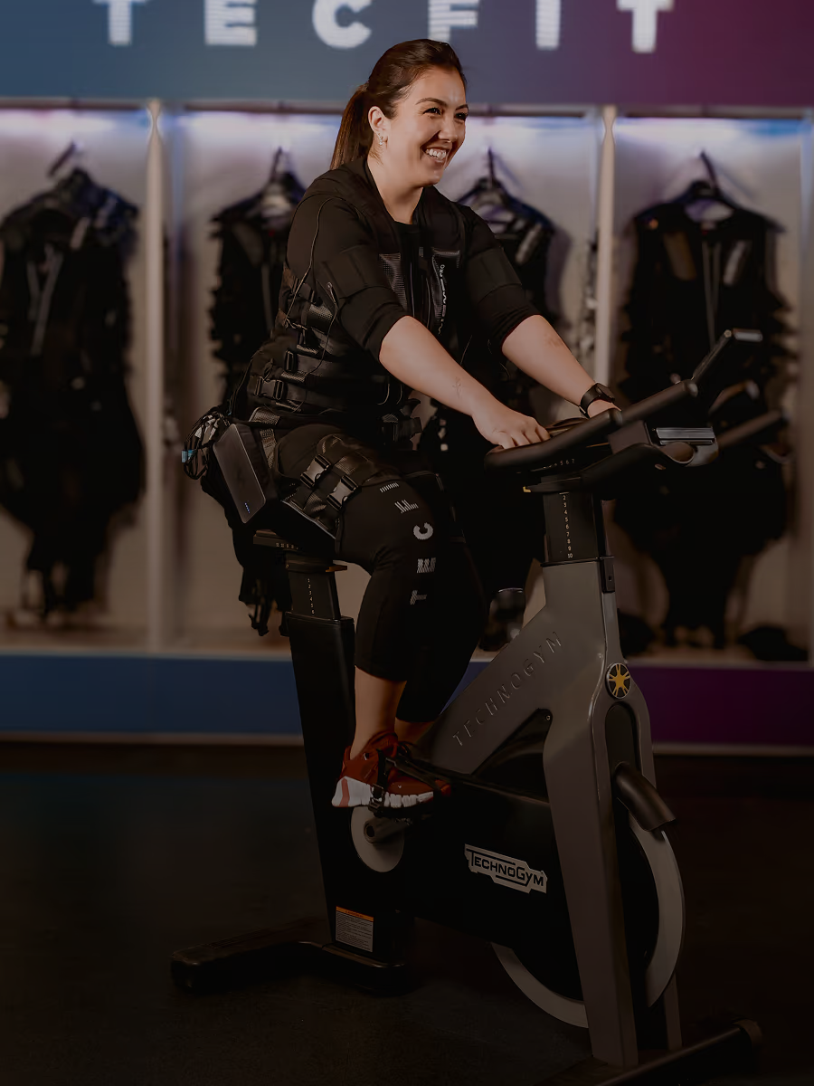 Aluno em traje completo de eletroestimulação treinando em aparelho na Tecfit